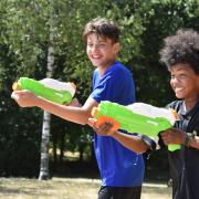 Rares Tausanu and Malachi Quayson having a water fight in Eaton Park during the heatwave