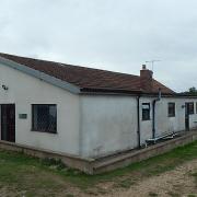 A four-bed bungalow set in over an acre of grounds has come up for sale at auction