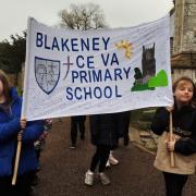 Pupils from Blakeney Primary School carrying their banner