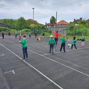 Primary school children learn tennis on a visit to Cromer tennis club