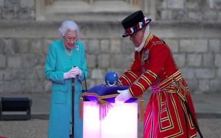 Queen Elizabeth II symbolically leads the lighting of the principal Jubilee beacon at Windsor Castle. The cushion on which the crown and globe rest was made in Felmingham, north Norfolk, by Jon Rhodes